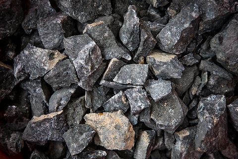 Crushed tin ore — dark cassiterite-bearing rock fragments